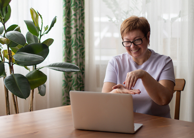 A woman communicates using sign language while on a video call